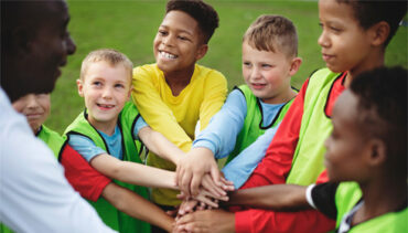 Young athletes huddled together before game.